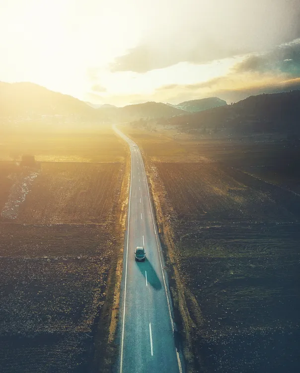 Fahrzeug auf einer Autobahn bei Sonnenuntergang – Symbol für Fahrleistung und Langstreckenkomfort