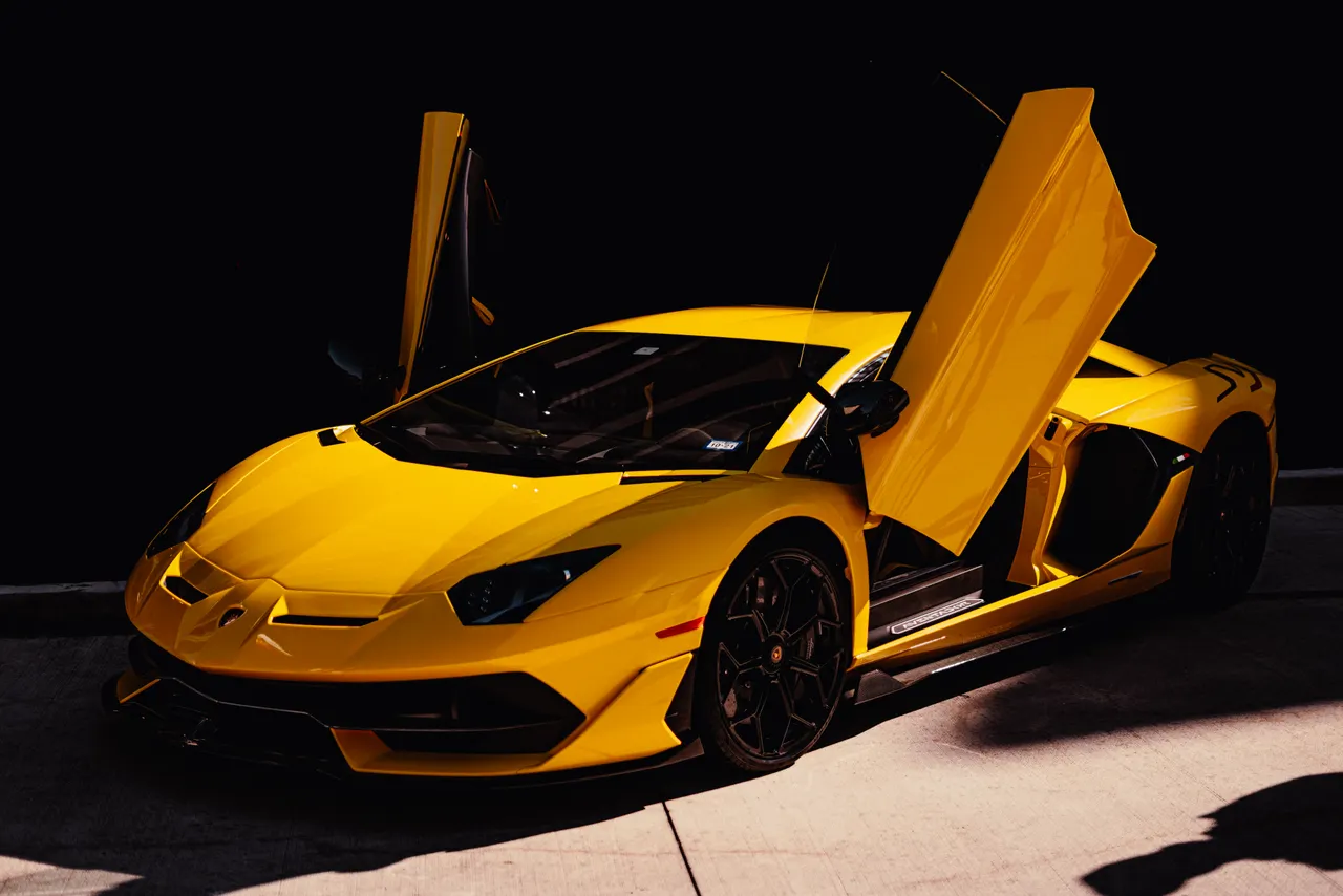 Gelber Lamborghini Aventador mit geoeffneten Scheretueren bei einer Automobilausstellung