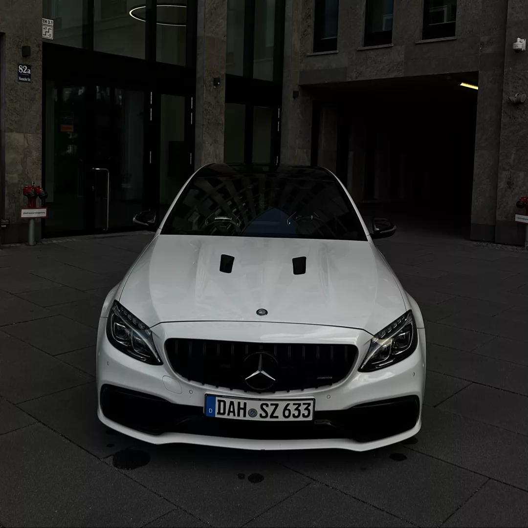 Hand hält einen Mercedes-Benz Fahrzeugschlüssel – symbolisch für die Fahrzeugübergabe beim Mieten