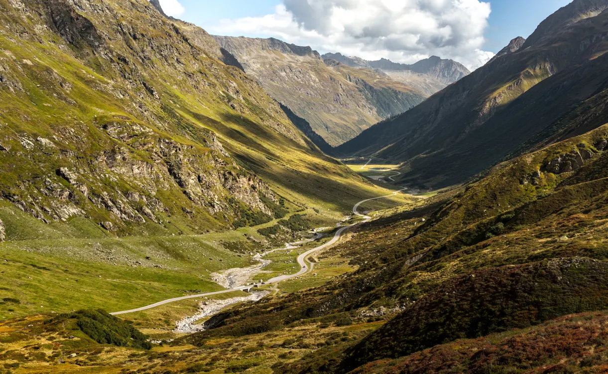 Malerische Serpentinenstraße durch die österreichischen Alpen unter bewölktem Himmel