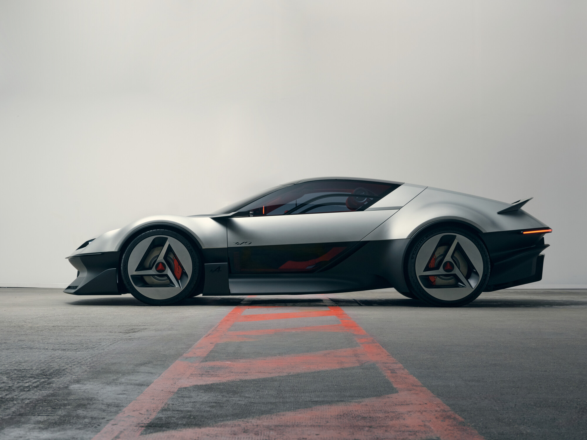 Weißes Elektro-Konzeptauto in modernem minimalistischen Showroom – Ausblick auf Alpines elektrische Zukunftsmodelle