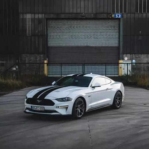 Ford Mustang GT 5.0 V8 in Weiß mit schwarzen Streifen, Frontansicht mieten.