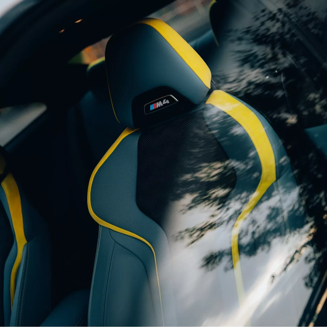 BMW M4 Competition Sportsitz mit gelben Akzenten mieten.