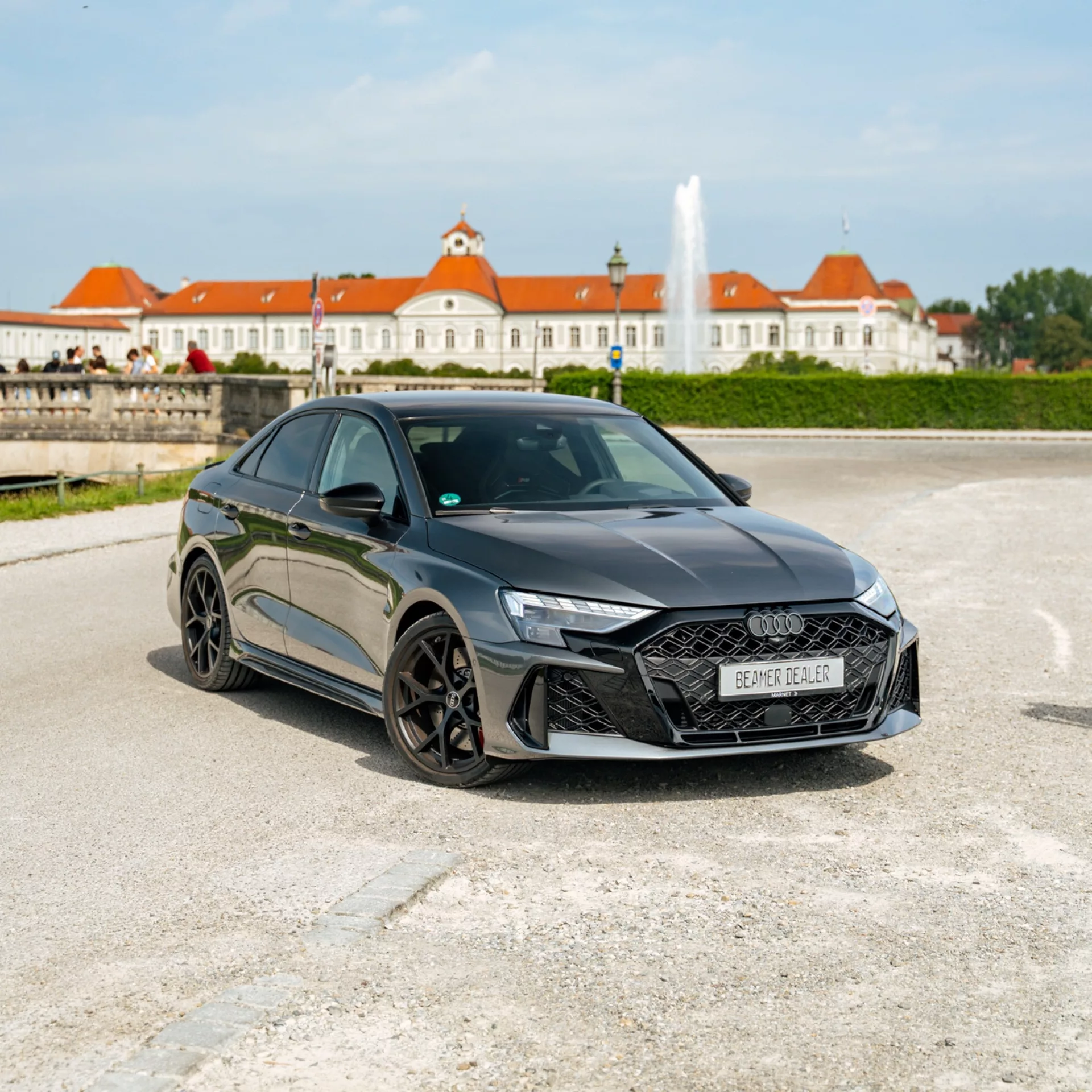 Audi RS3 FACELIFT in Grau mieten - Frontansicht mit Schloss im Hintergrund.