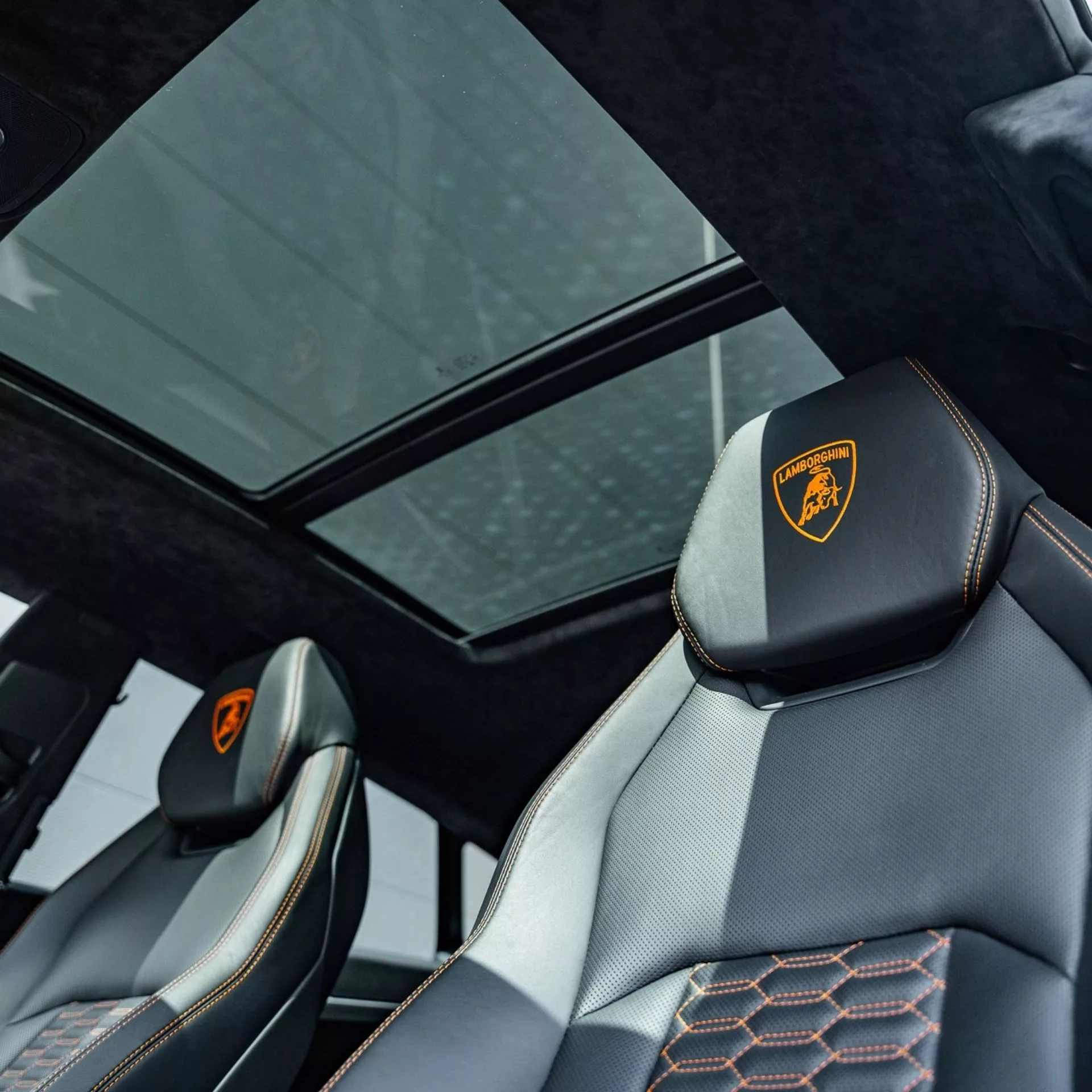 Innenraum eines Lamborghini Urus mit luxuriösen Ledersitzen und Panoramadach.