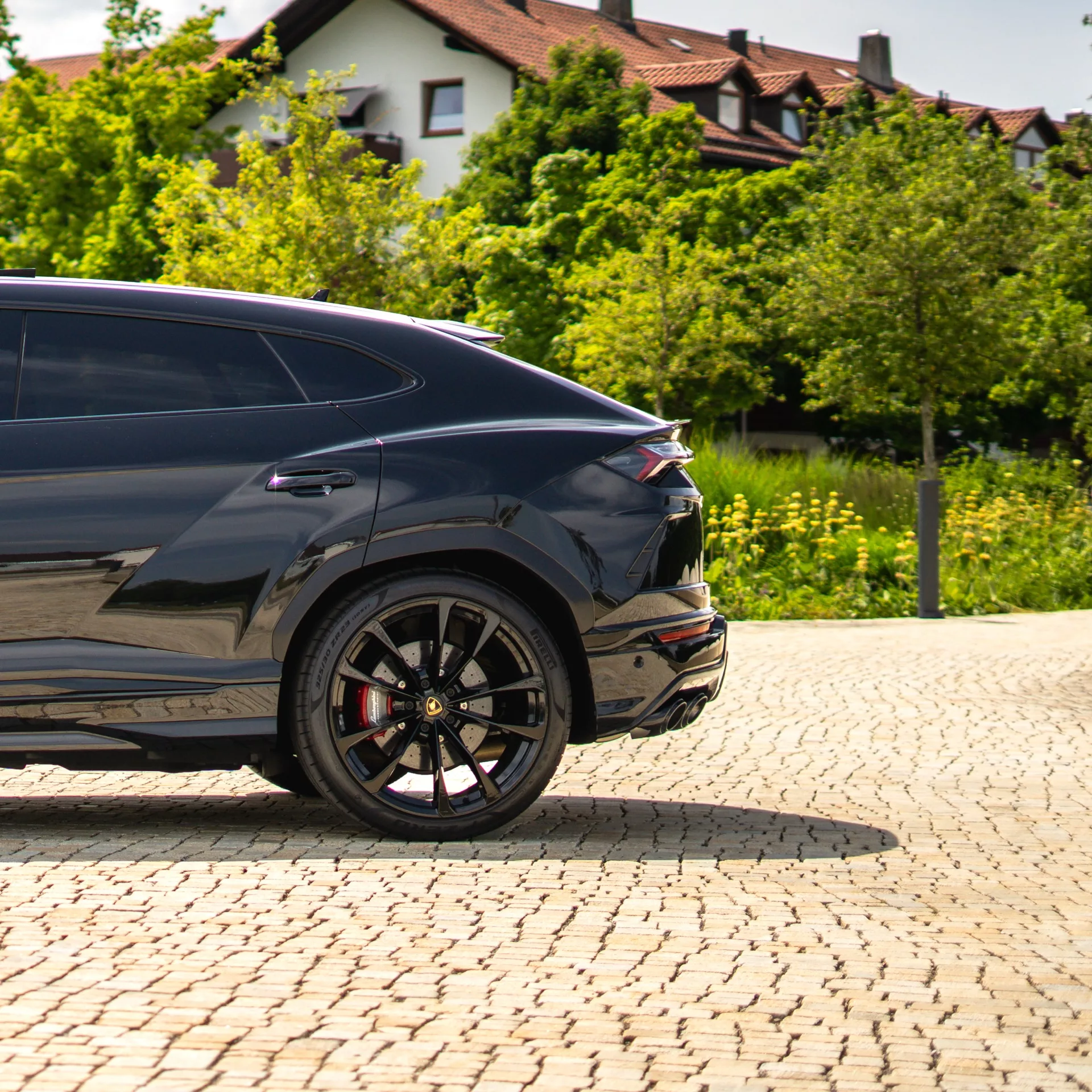Lamborghini Urus in Schwarz, Seitenansicht, parkend vor Häusern mieten