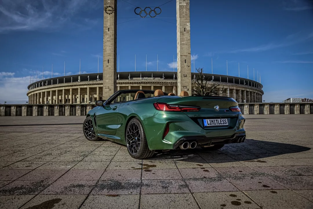 BMW M8 Competition Cabrio in Grün mieten - Rückansicht vor Stadion