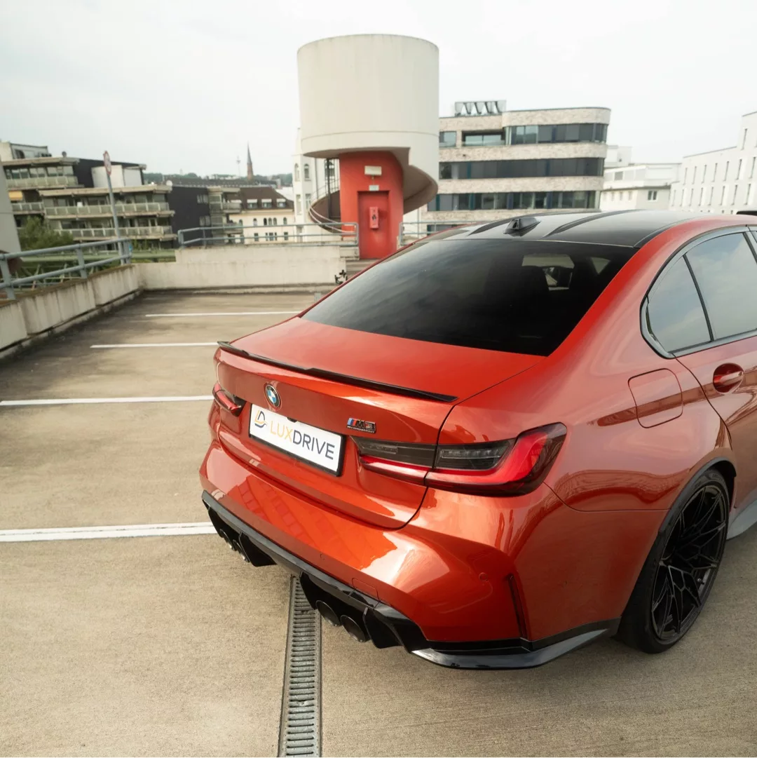 BMW M3 Competition in Orange, Heckansicht mieten