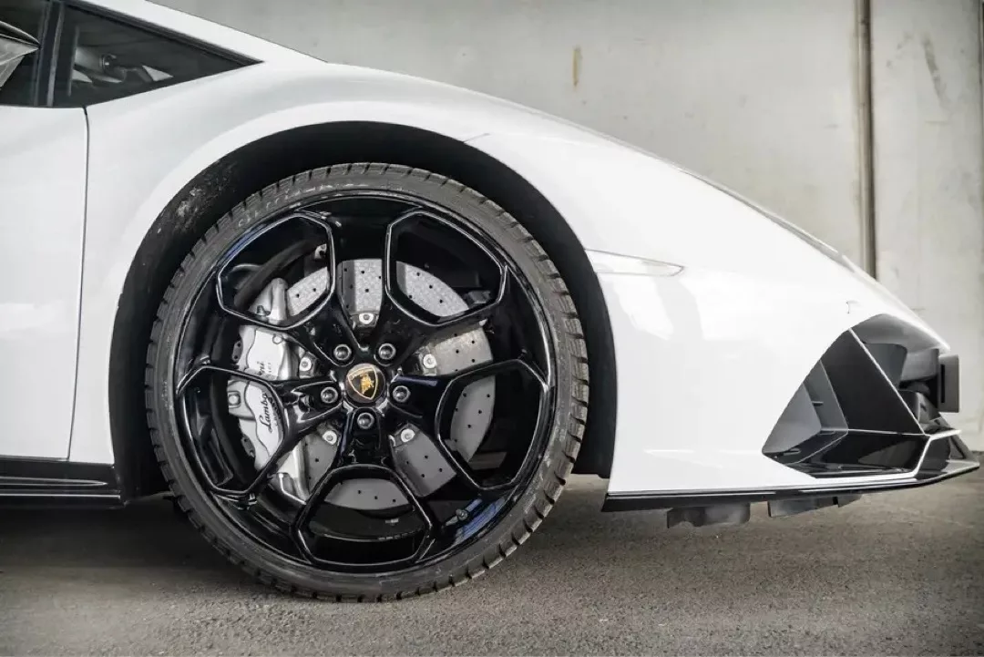 Weißer Lamborghini Huracán EVO, Seitenansicht mit Fokus auf Vorderrad und Felge.