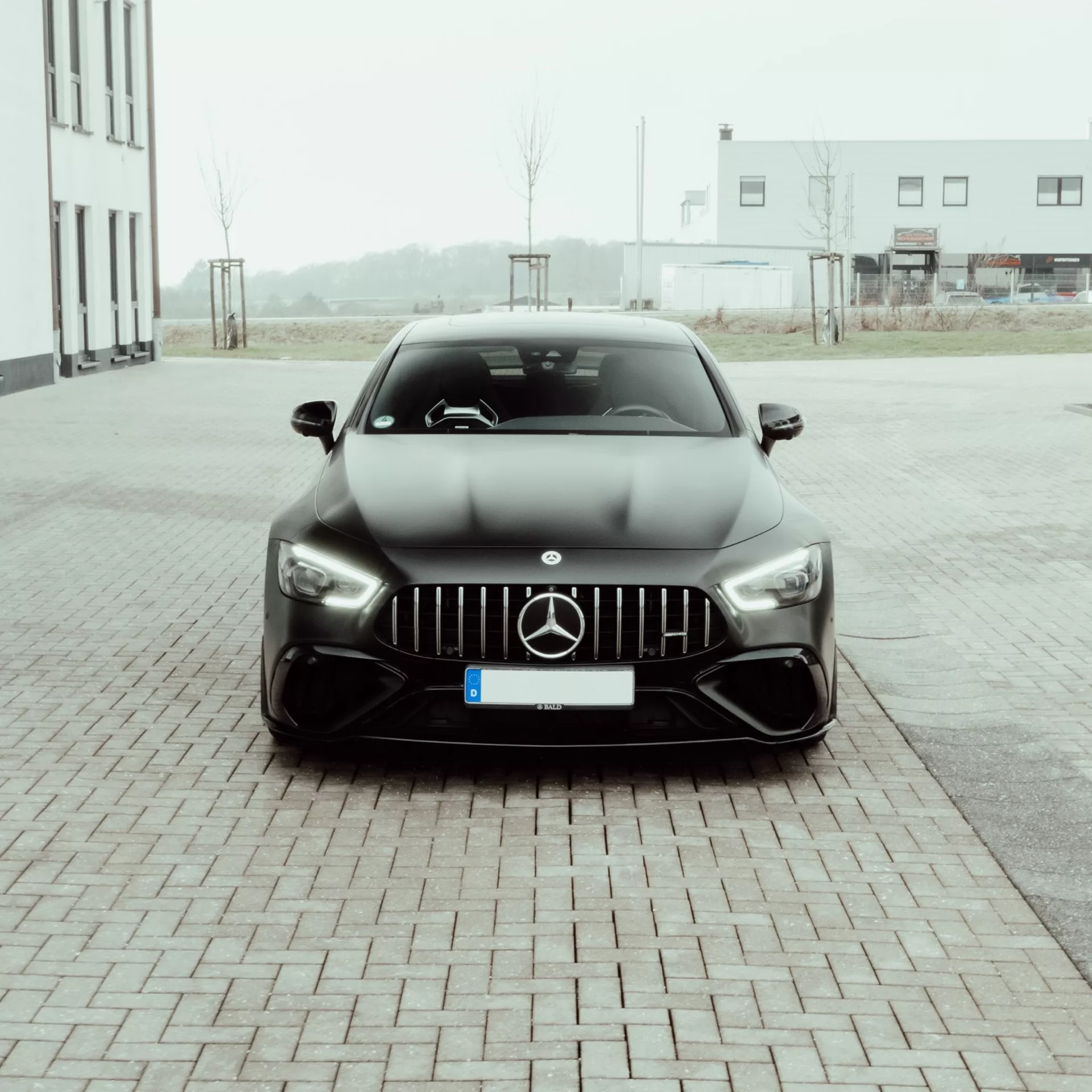 Mercedes GT63S AMG in Grau, Frontansicht, auf Parkplatz mieten.