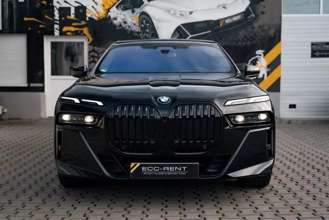 Luxuriöser schwarzer BMW 740d M xDrive auf gepflastertem Platz.