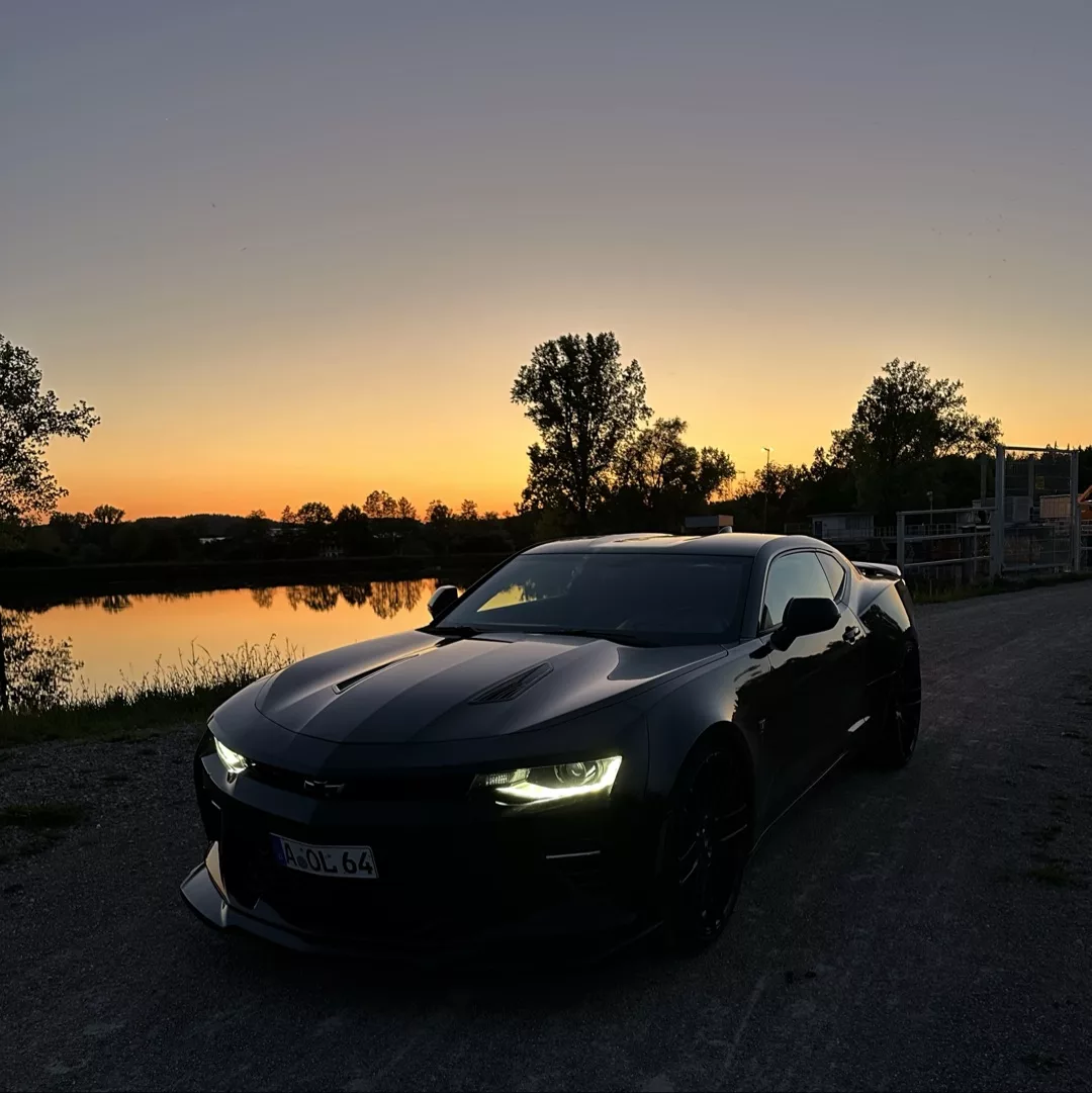 Chevrolet Camaro 6.2 V8 Customkingz in Schwarz bei Sonnenuntergang mieten.