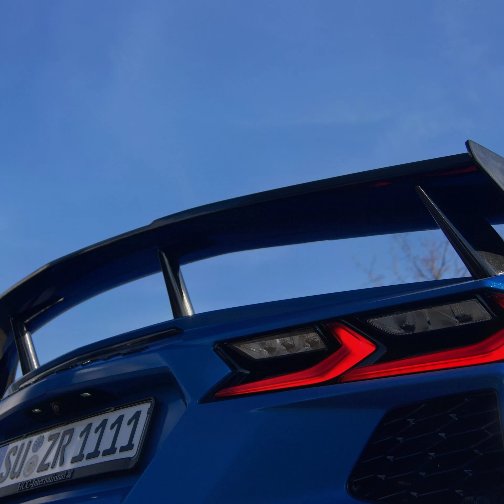 Corvette C8 Heckansicht in Blau mit Spoiler mieten.