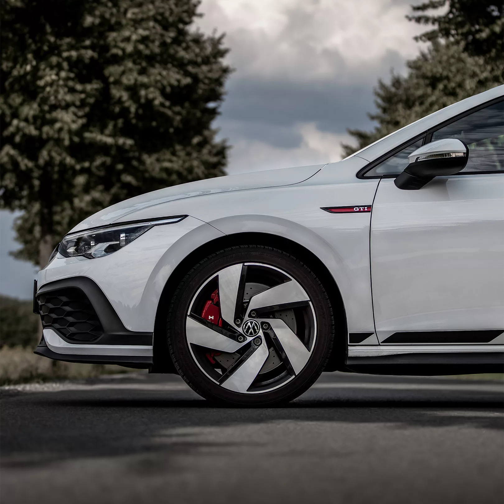 VW Golf 8 GTI Clubsport in Weiß, Seitenansicht des Vorderwagens, mieten.