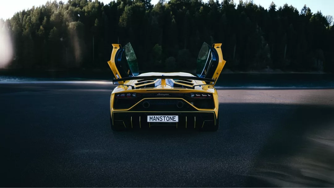 Lamborghini Aventador SVJ Coupé Heckansicht in Gelb mit offenen Flügeltüren mieten.