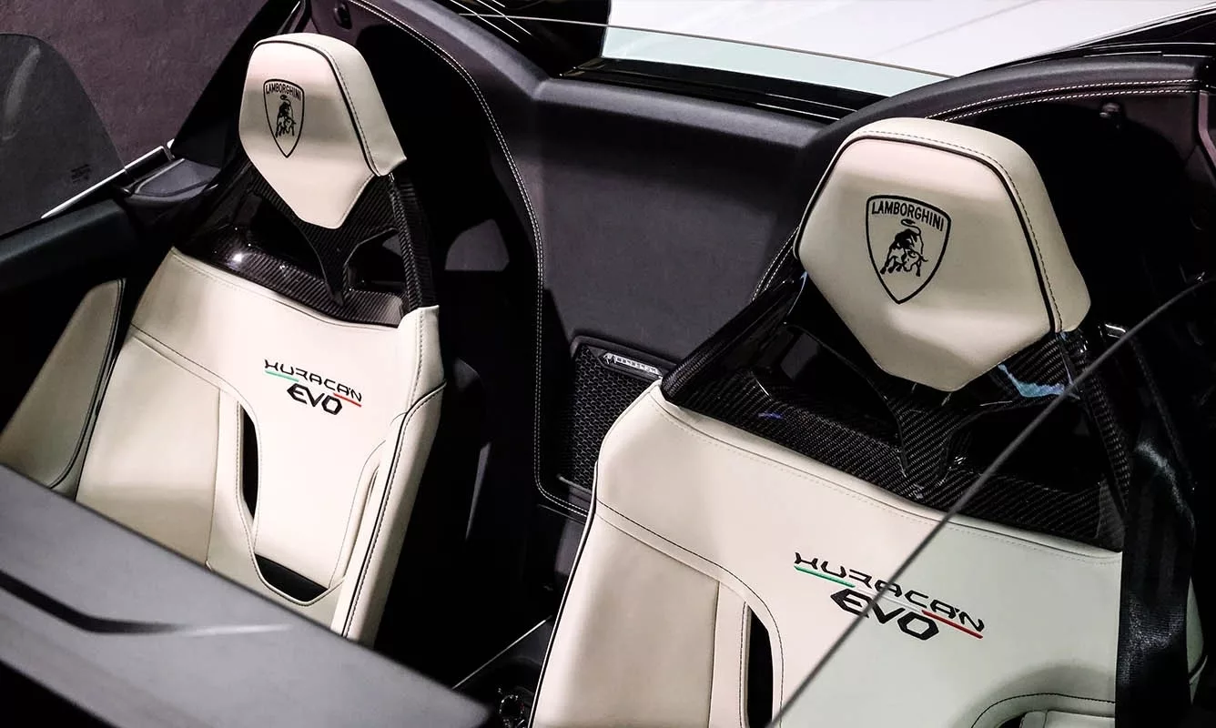 Innenraum eines Lamborghini Huracan EVO Spider mit weißen Sportsitzen.