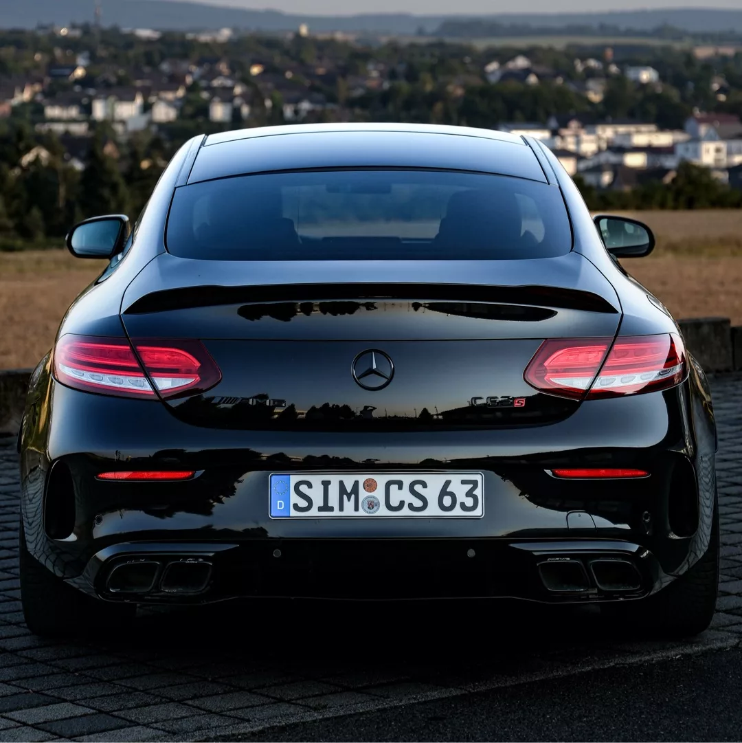 Mercedes Benz C63s AMG Coupé in Schwarz von hinten mieten.
