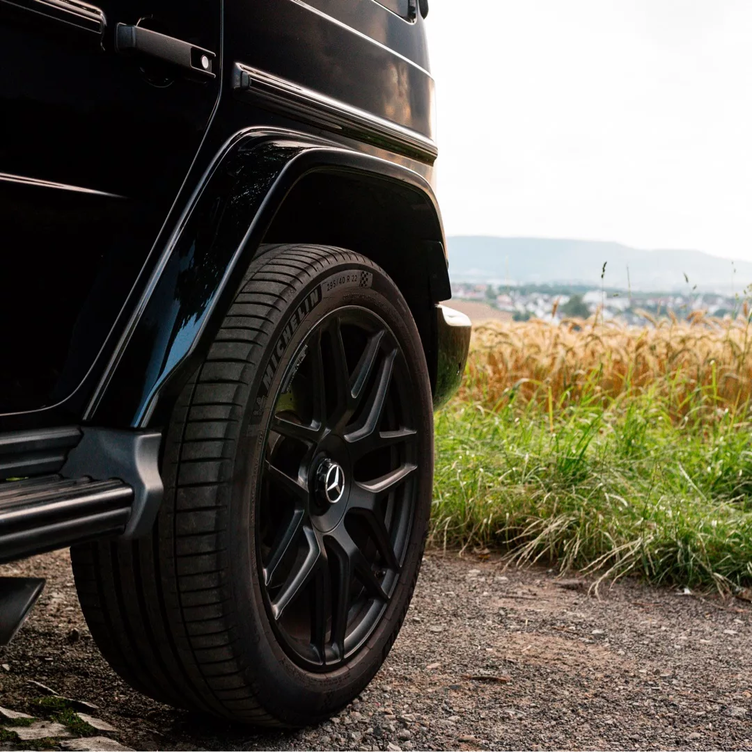 Mercedes G63 AMG in Schwarz mit Nahaufnahme des Hinterrads mieten