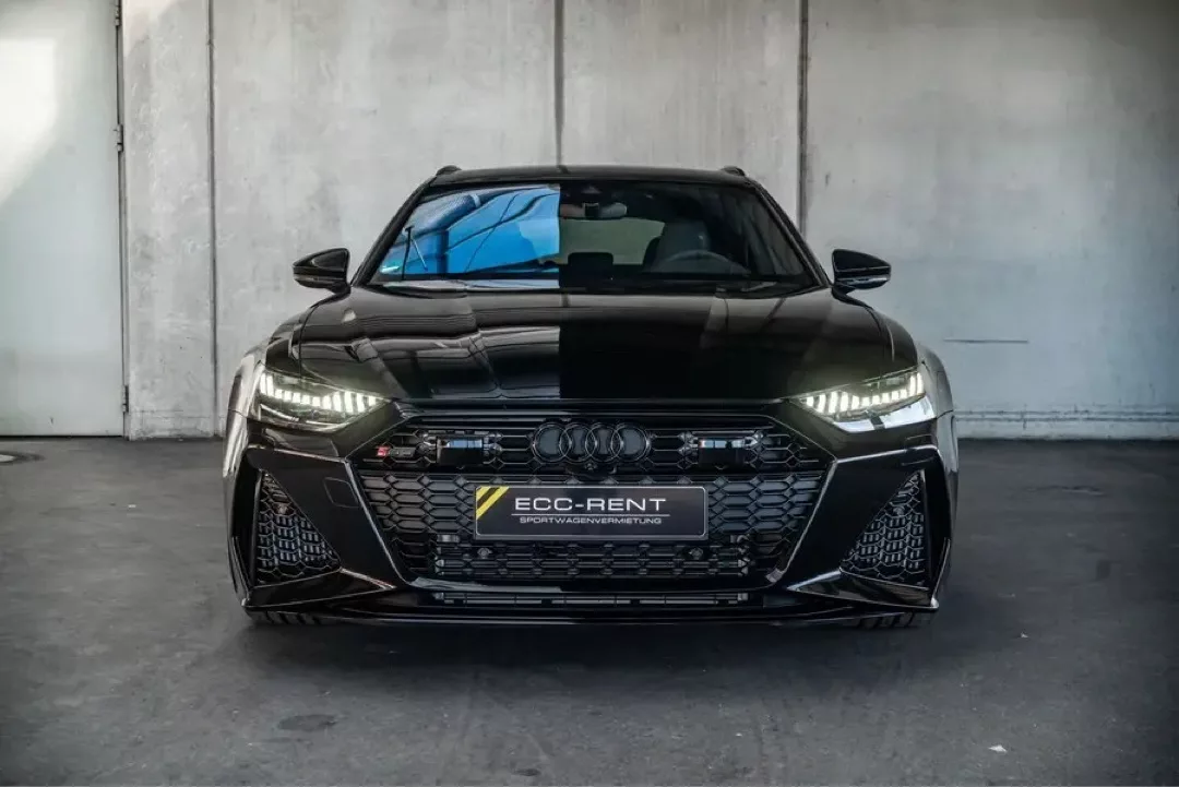 Frontansicht eines schwarzen Audi RS6 mit markanten LED-Scheinwerfern.
