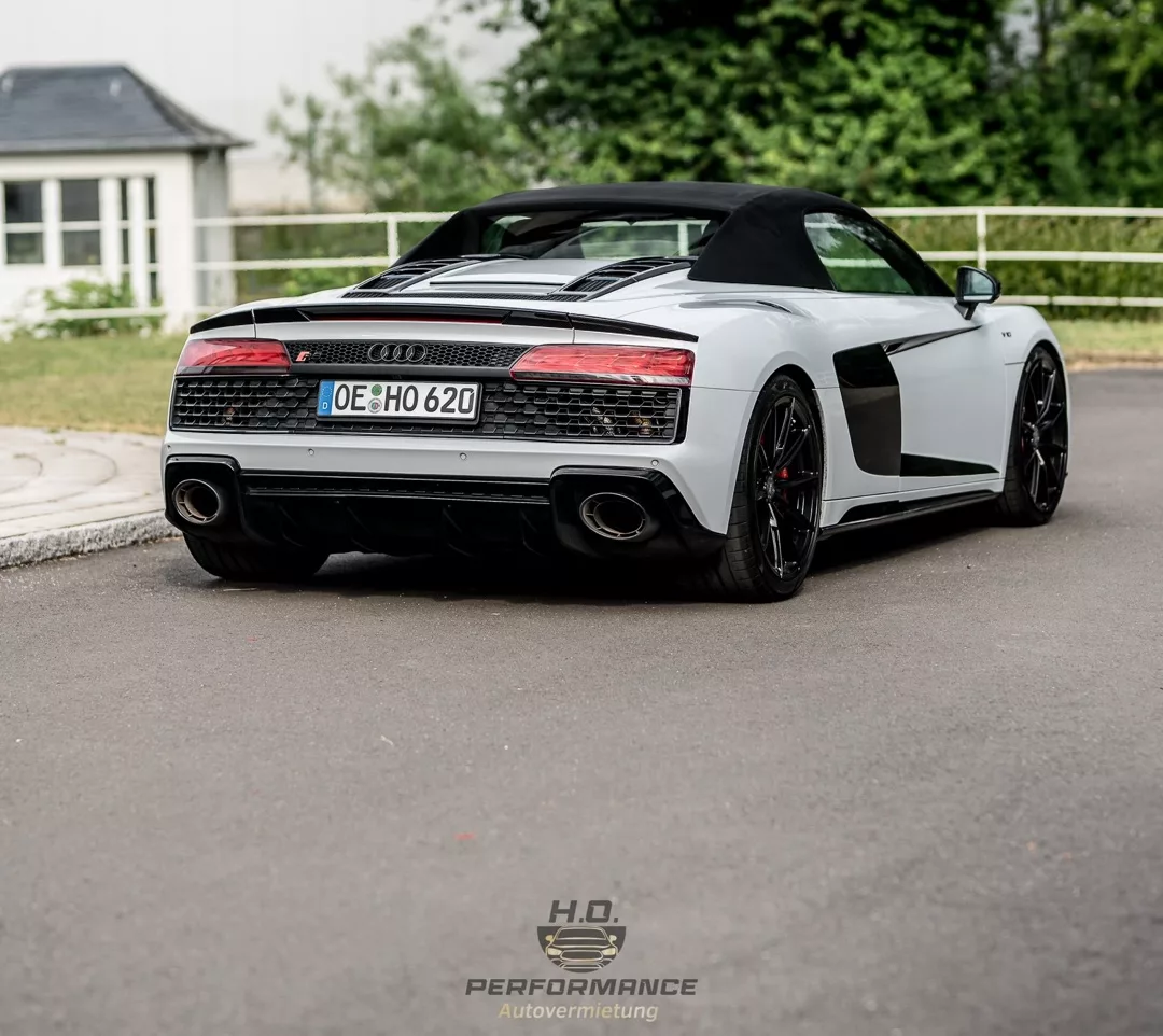 Audi R8 Performance Spyder in Weiß, Heckansicht auf Straße mieten.