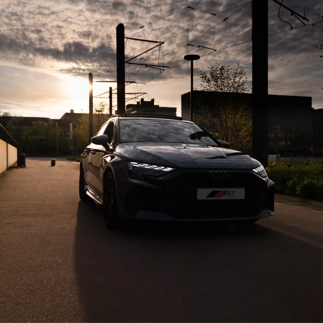 Audi RS3 Facelift Limousine in Schwarz, Frontansicht bei Sonnenuntergang mieten.