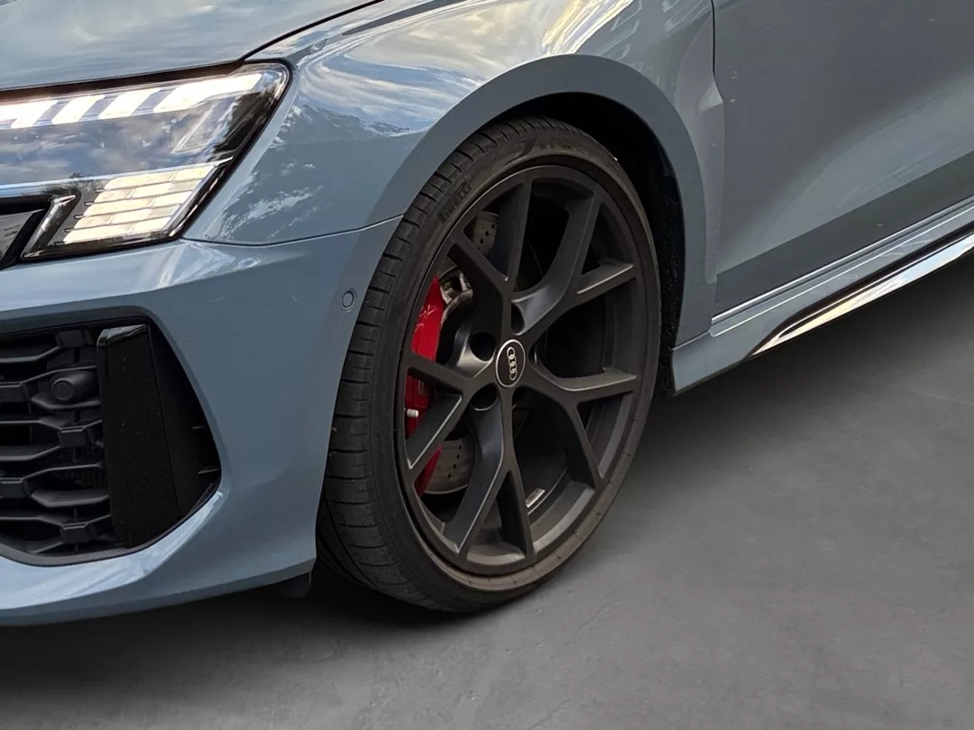 Audi RS3 in Grau, Nahaufnahme des Rades mit roten Bremssätteln mieten.