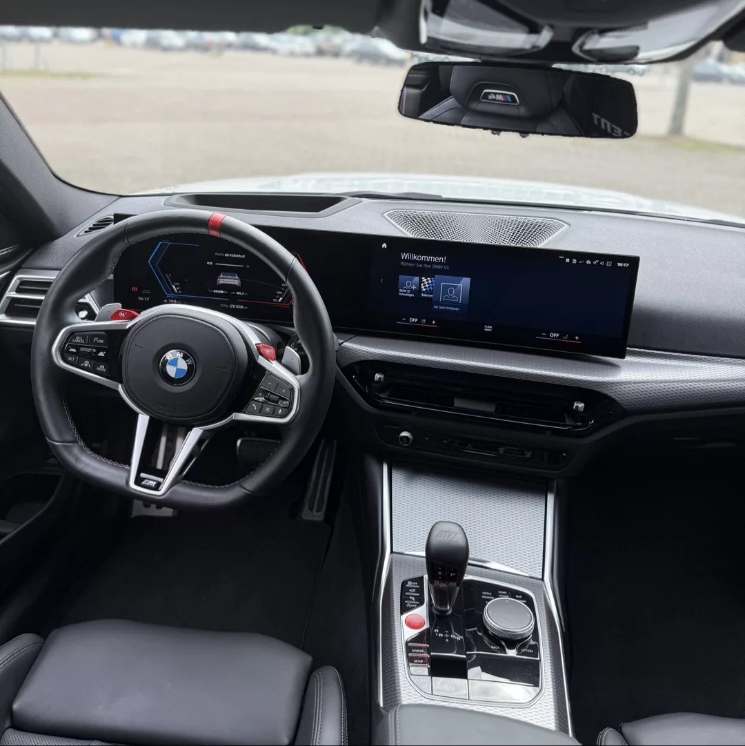 BMW M4 Competition Innenraum mit Display und Lenkrad mieten.