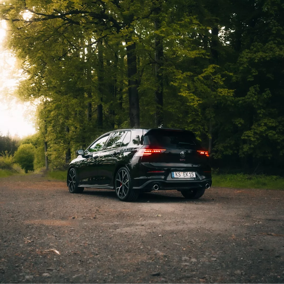 Golf 8 GTI Facelift in Schwarz von hinten im Wald mieten