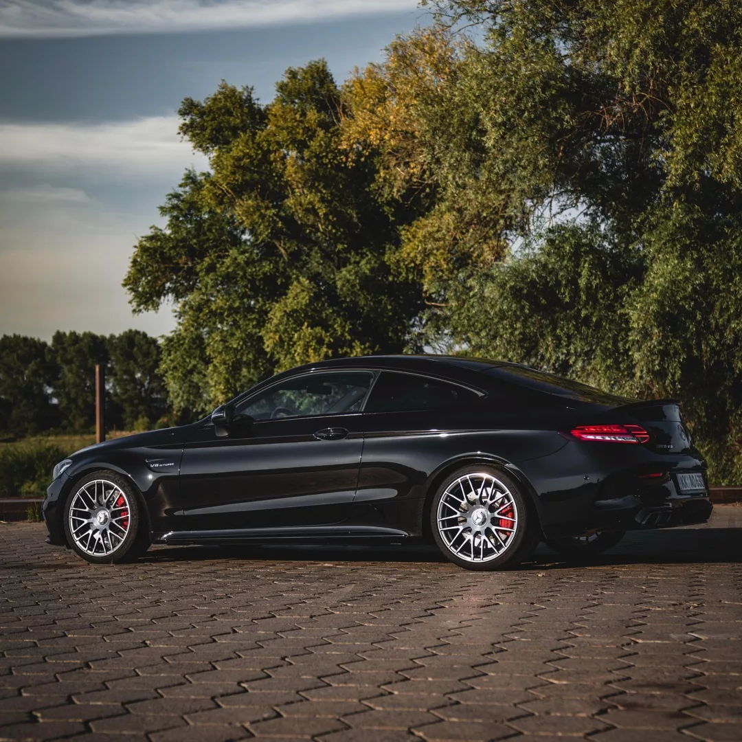Mercedes C63s Coupé in Schwarz von der Seite mieten