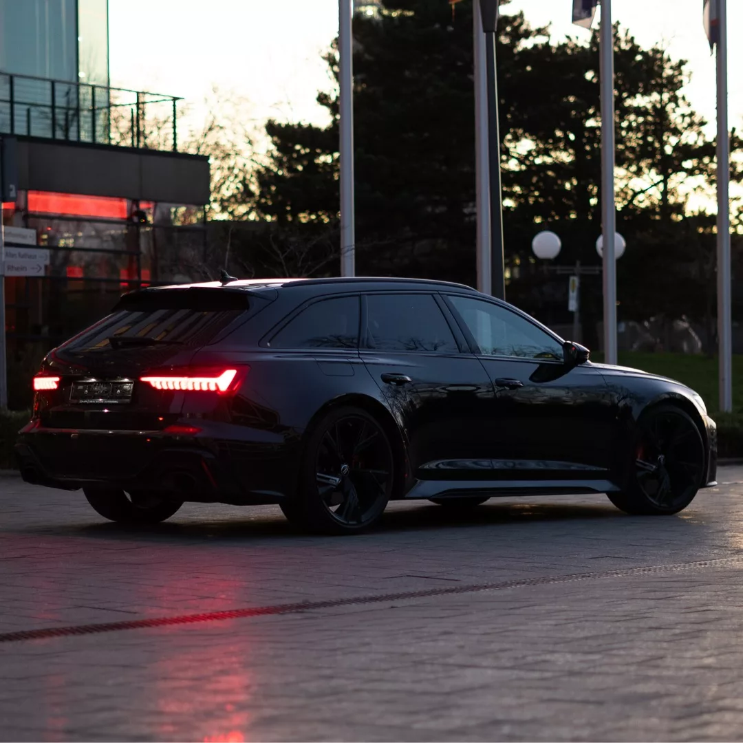 Audi RS6 in Schwarz von hinten bei Sonnenuntergang mieten.