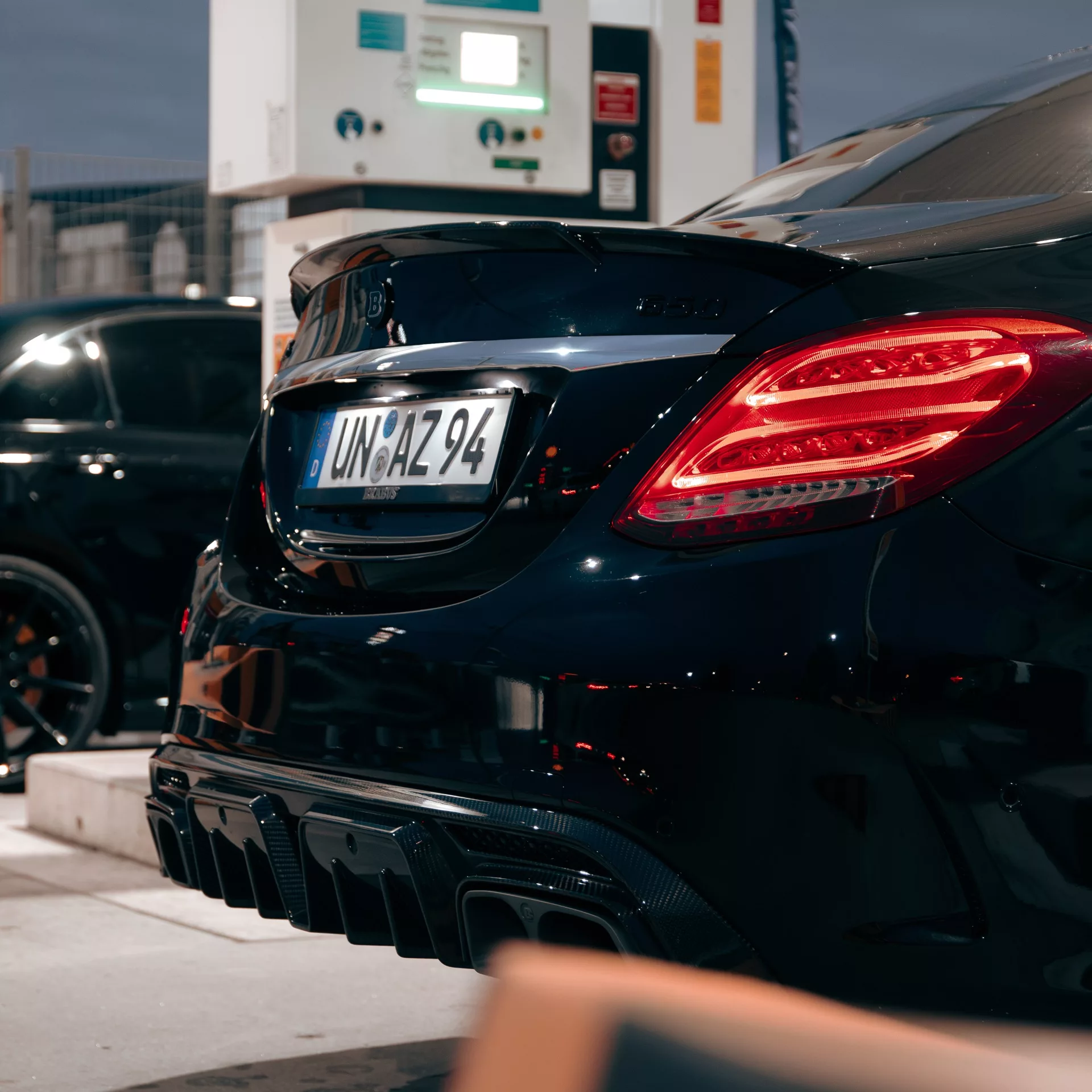 BRABUS B650 in Schwarz von hinten bei Tankstelle mieten.