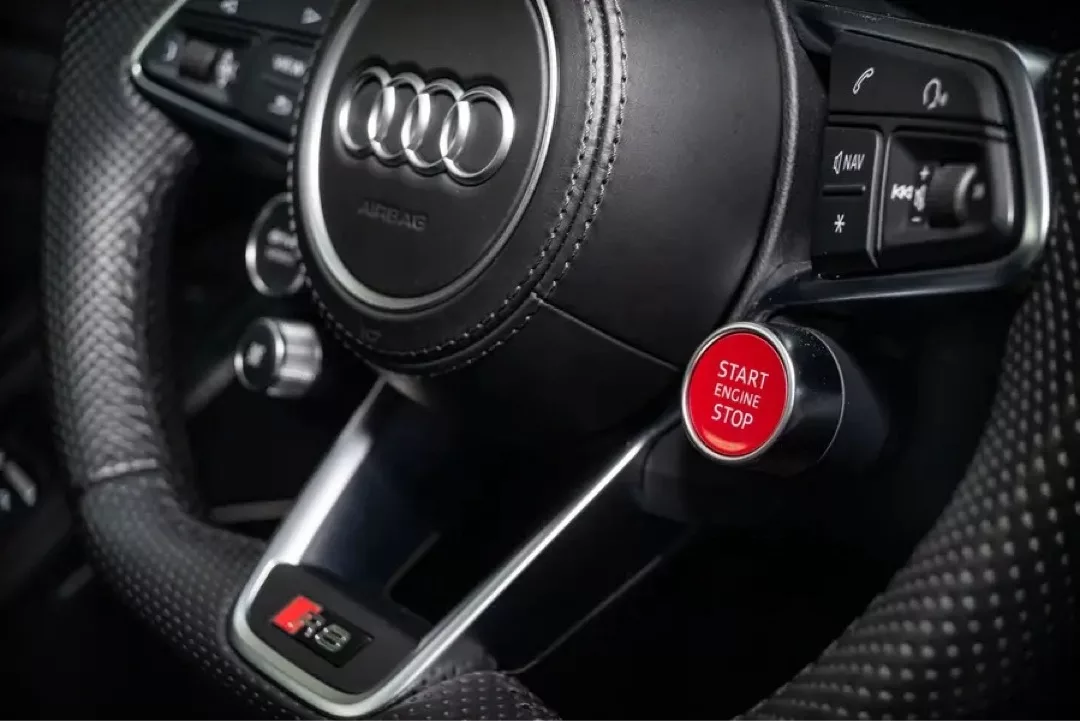 Nahaufnahme des Lenkrads eines Audi R8 V10 Performance Coupés mit Start-Stopp-Knopf.