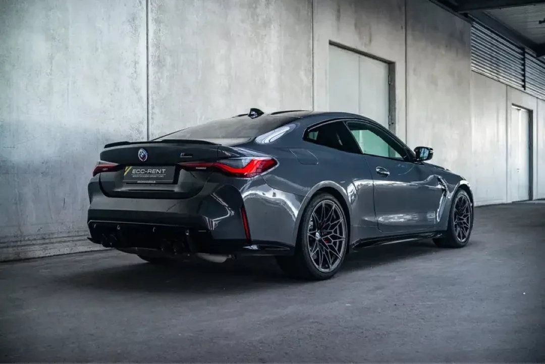 Grauer BMW M4 Competition 50 Jahre in einer Garage von hinten betrachtet.