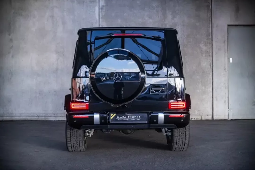 Schwarzer Mercedes-Benz G63 AMG von hinten, in einer Garageneinfahrt.