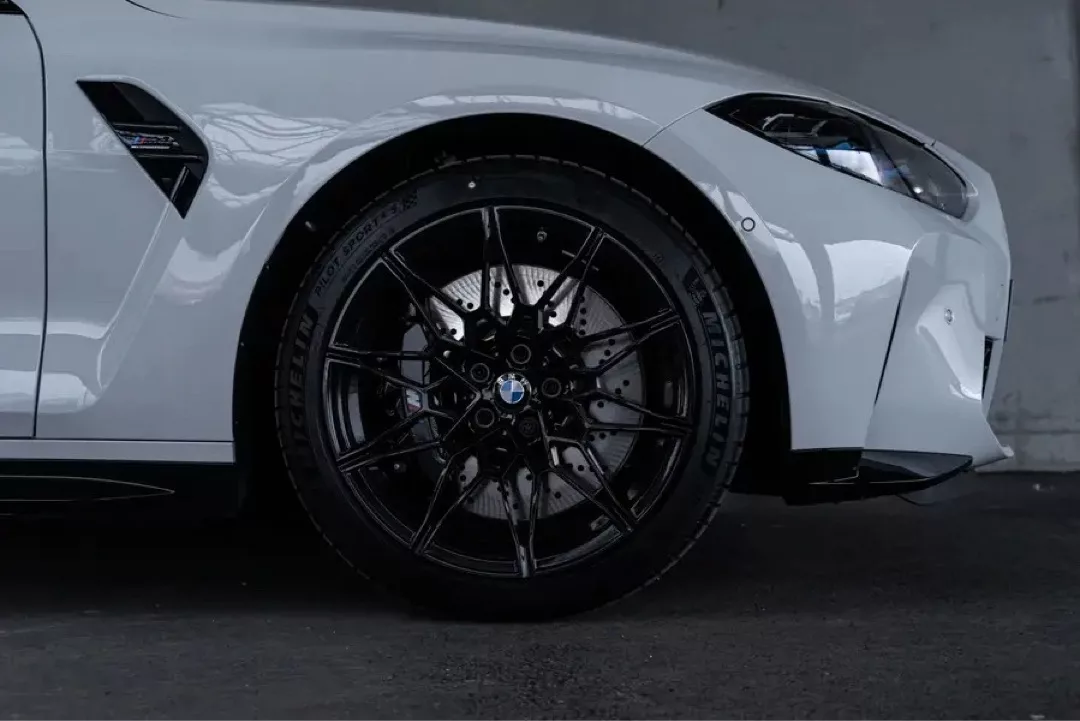 Weißer BMW M4 Cabrio Competition in Nahaufnahme von der Seite.