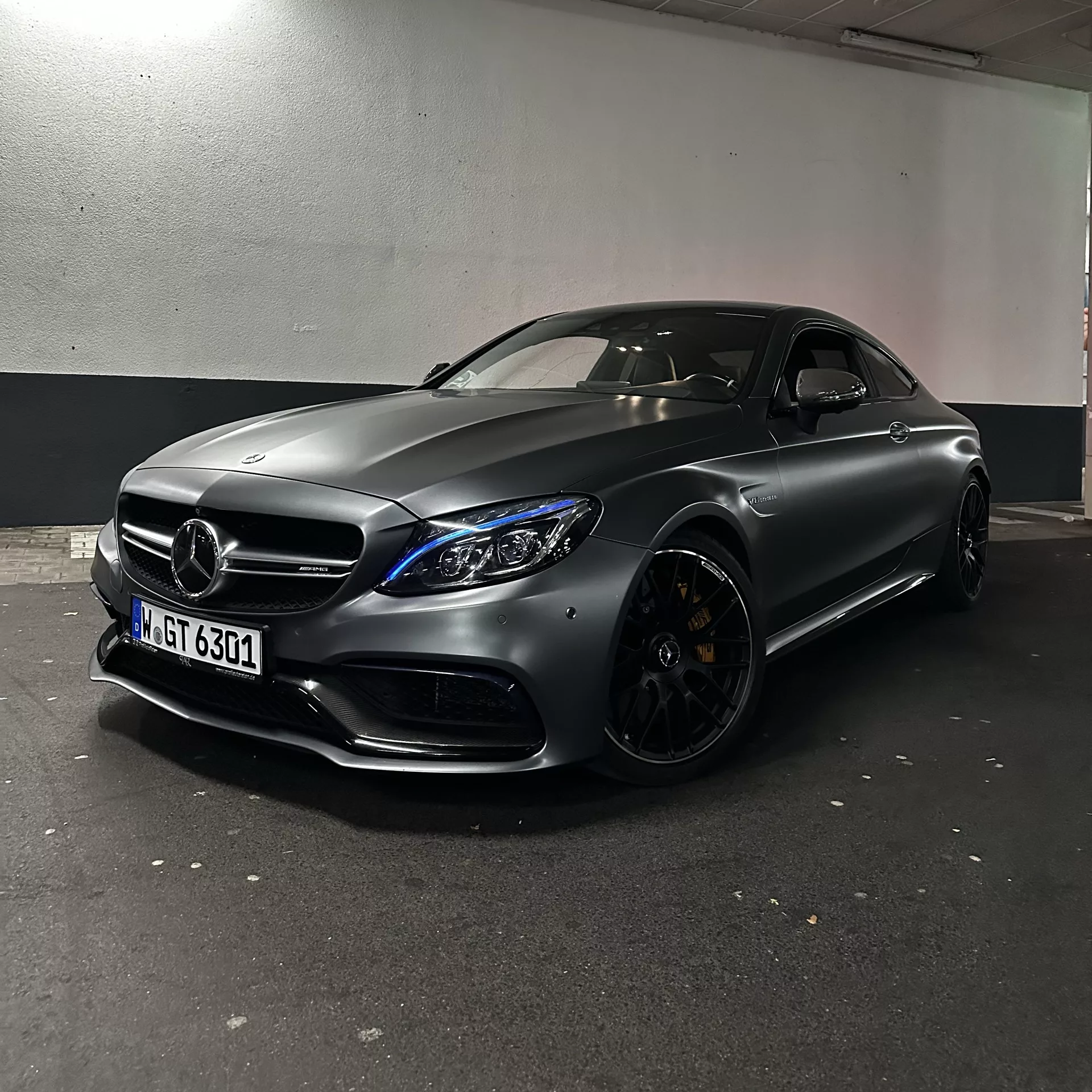 Mercedes C63s AMG in Mattschwarz von schräg vorne mieten.