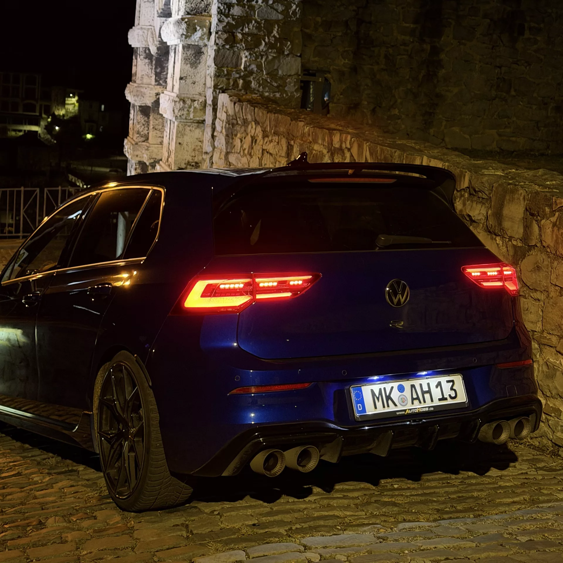 VW Golf 8 R Performance Akrapovic Rückansicht bei Nacht mieten.