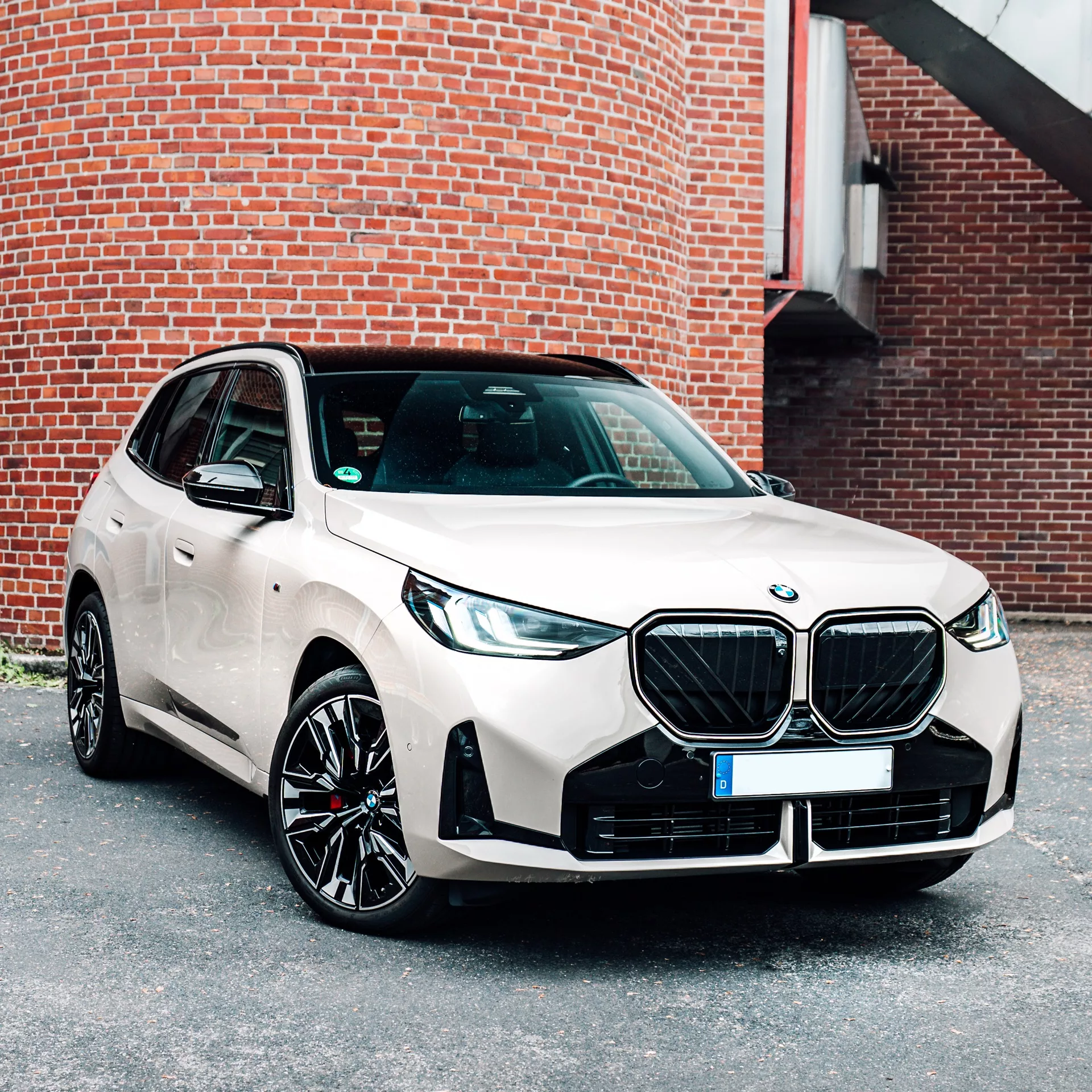 BMW X3 in Dune Grey mieten - Frontansicht vor Backsteinwand