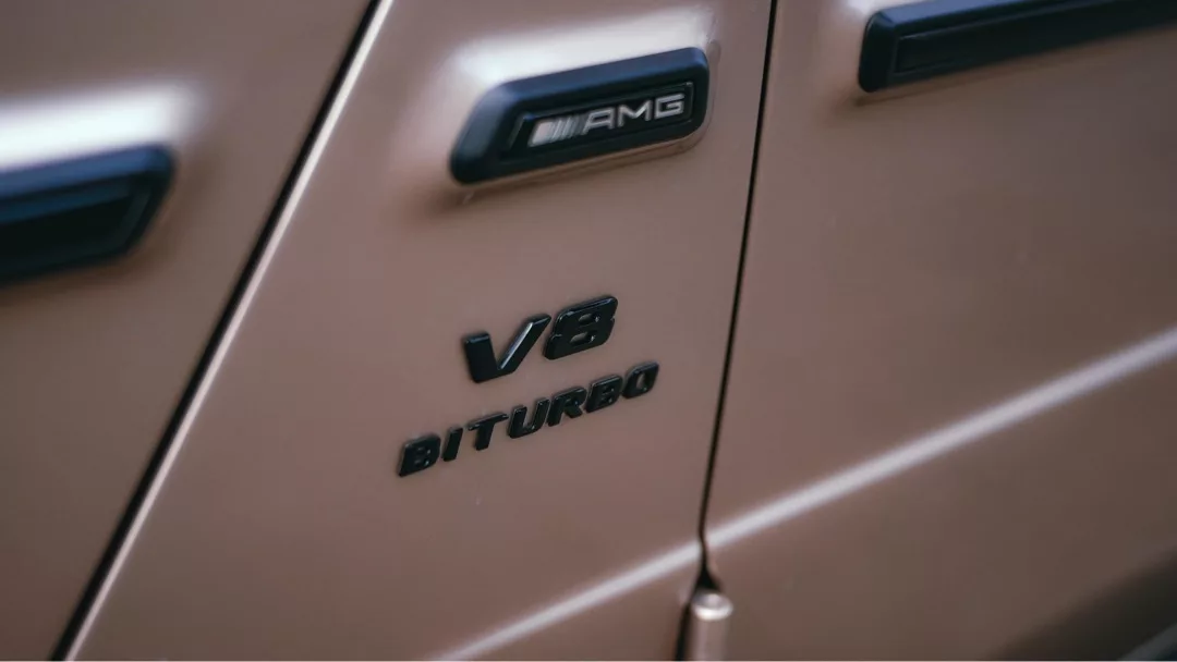 Mercedes-Benz G63 AMG Schriftzug auf beiger Karosserie mieten.