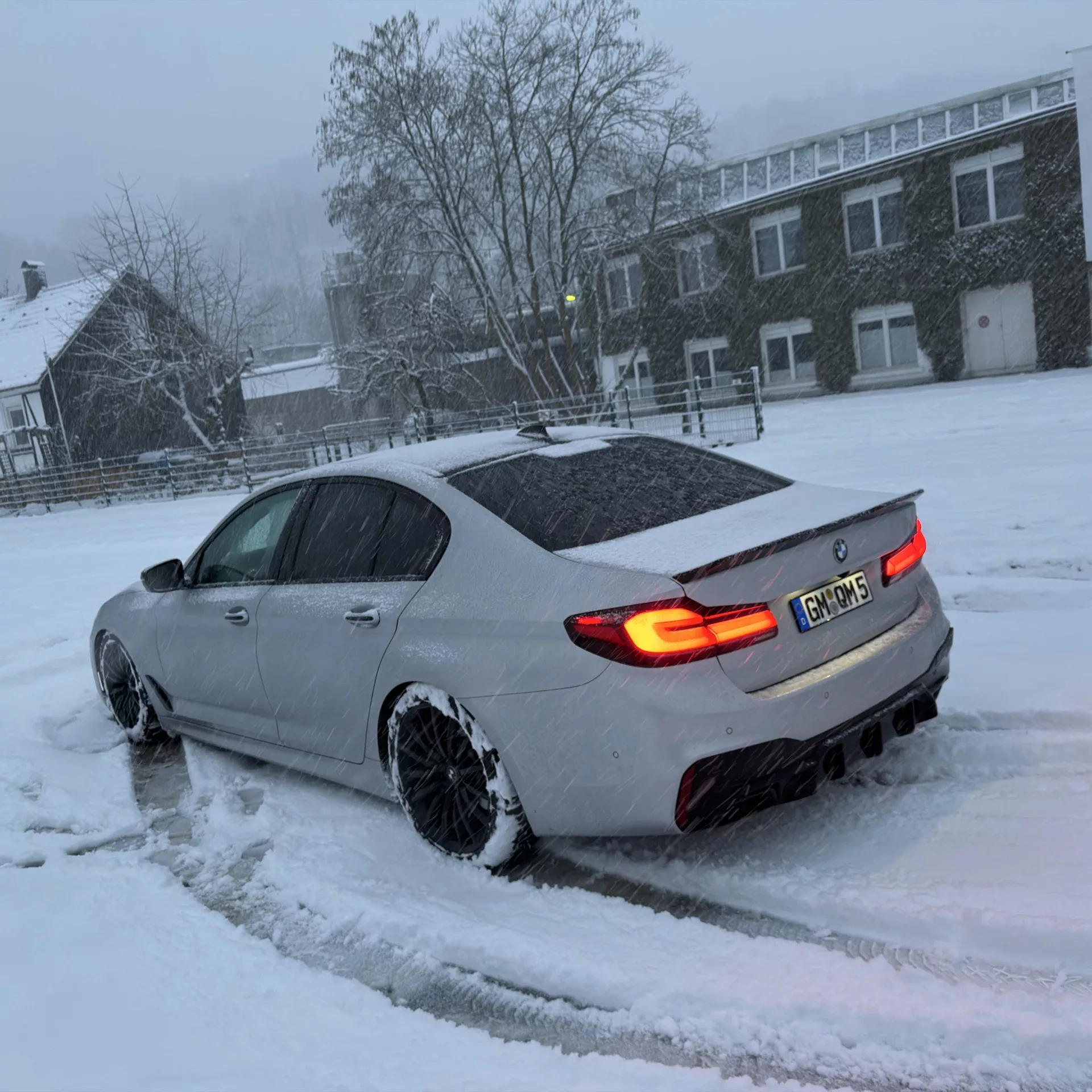 BMW m550i V8 in Schnee von hinten mieten