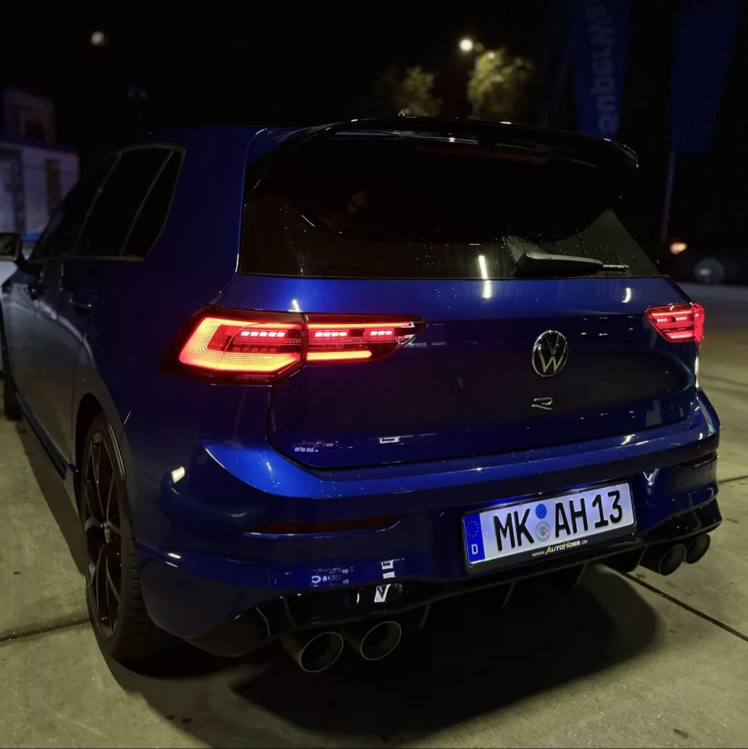 VW Golf 8 R Performance in Blau, Heckansicht bei Nacht mieten.
