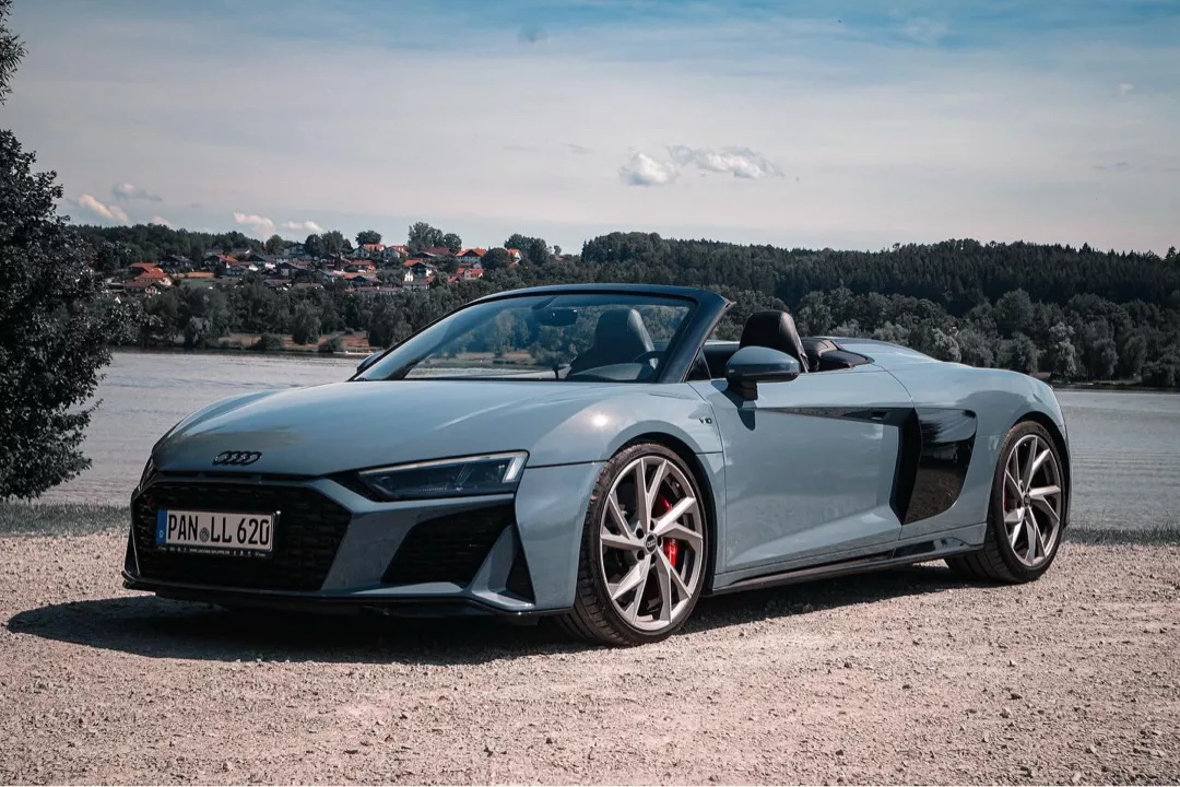 Audi R8 V10 Spyder Performance in Blau, Seitenansicht am See mieten.
