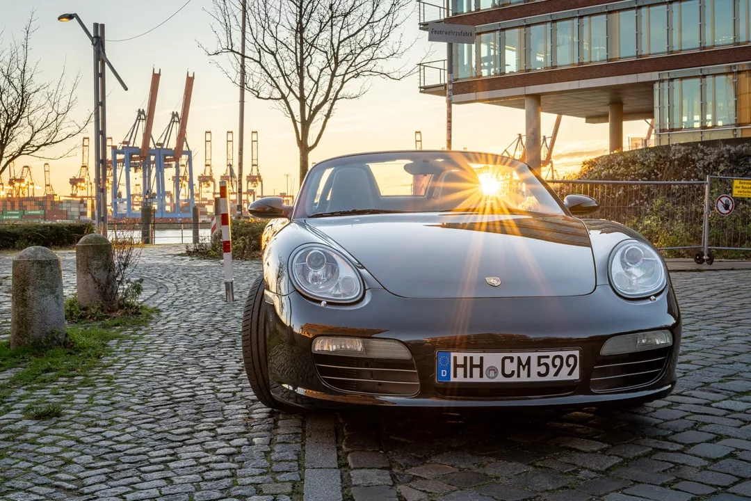 Porsche 987 Boxster S Cabrio in Schwarz, Frontansicht bei Sonnenuntergang mieten