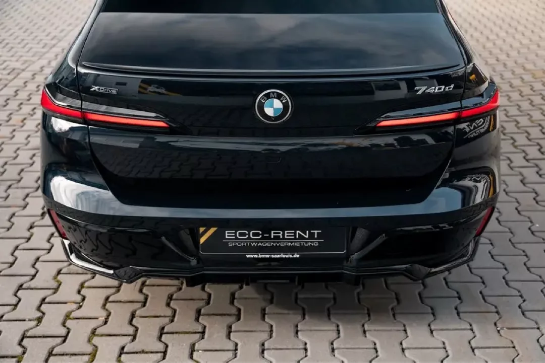 Luxuriöser schwarzer BMW 740d M xDrive von hinten auf Pflastersteinen.