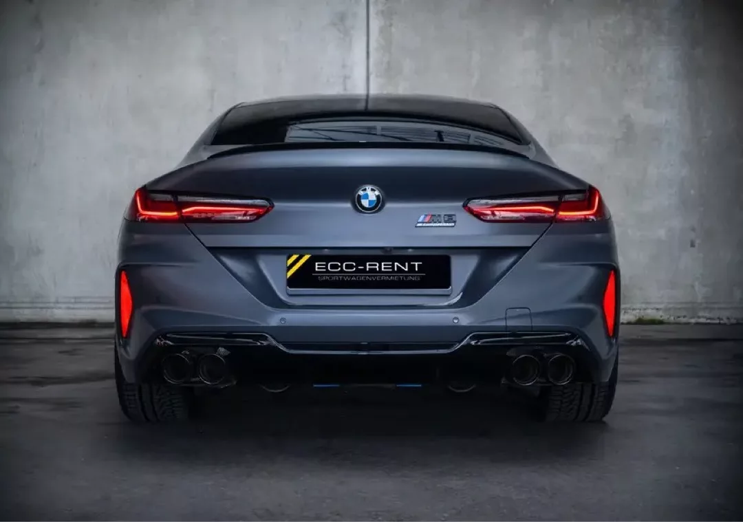 BMW M8 Gran Coupé in mattem Grau von hinten in einer Garage.