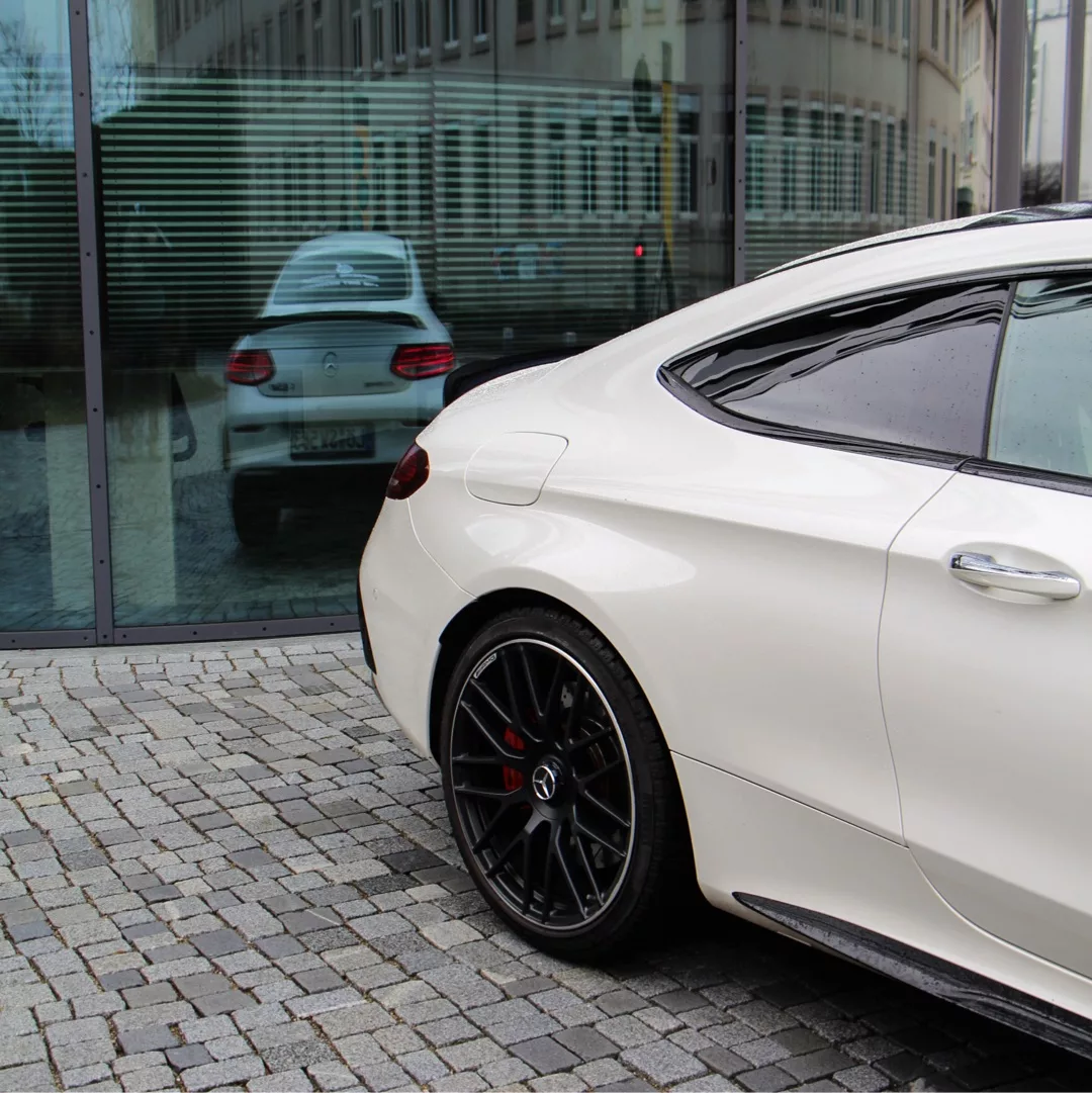 Mercedes-Benz C63s AMG Coupé in Weiß, Rückansicht seitlich mieten
