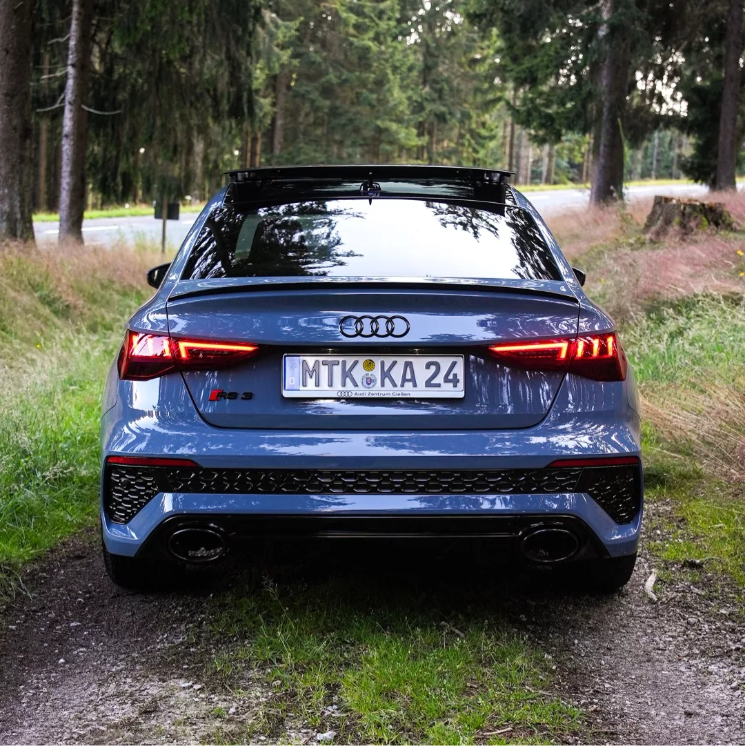 Audi RS3 in Grau von hinten auf Waldweg mieten
