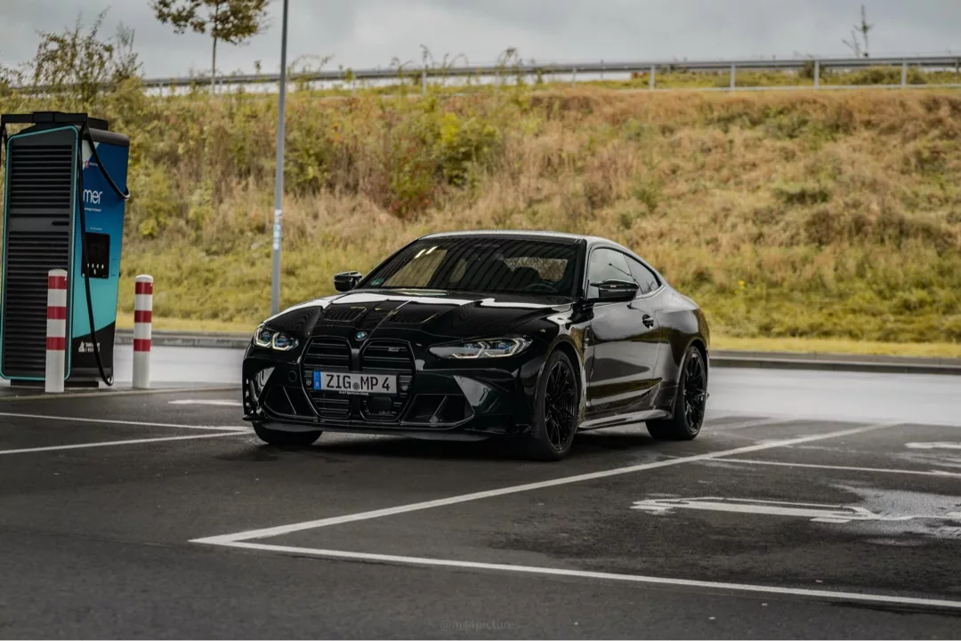 BMW M4 Competition in Schwarz auf Parkplatz mieten.