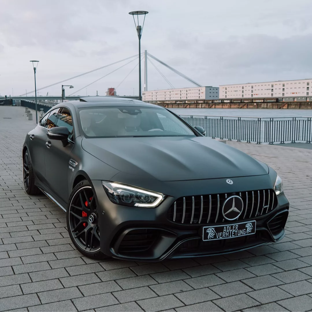 Mercedes-AMG GT 63 in Grau mieten - Frontansicht am Wasser.
