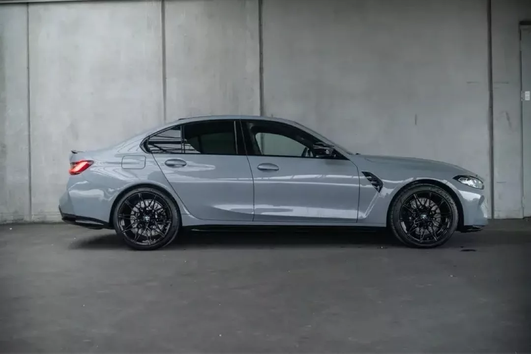 BMW M3 Competition, seitliche Ansicht in einer grauen Umgebung.